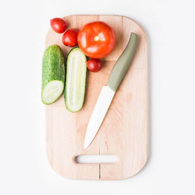 Cuchillo cerca de pepinos y tomates