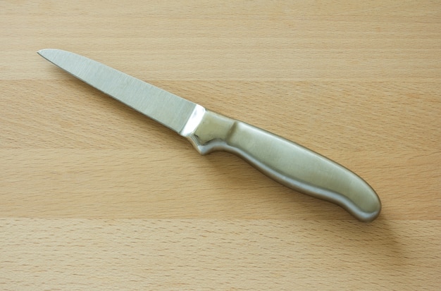 Cuchillo de cocina en tablero de madera marrón