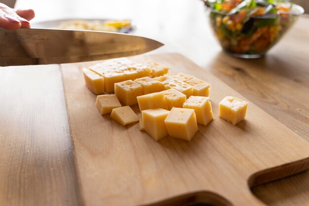 Cuchillo de corte de queso sobre tabla de madera