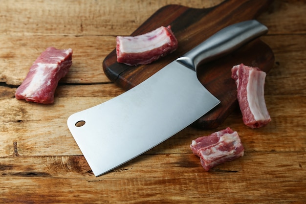 Cuchillo cuchilla y costillas en la tabla de madera