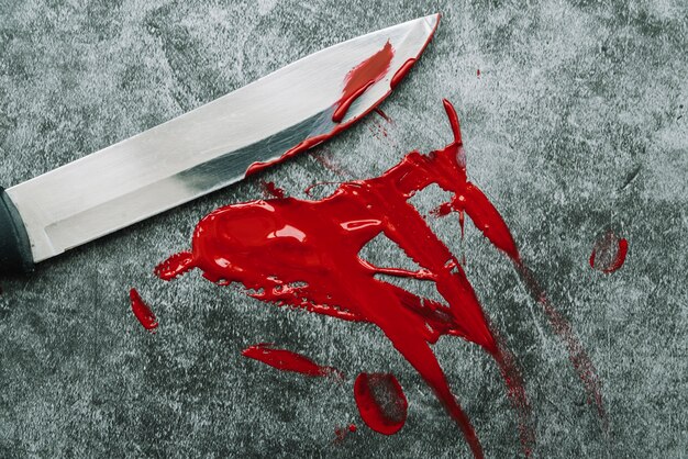 Cuchillo y untar sangre artificial en la superficie de la piedra