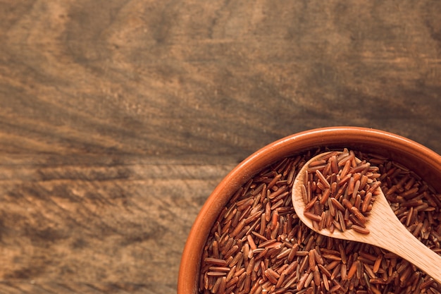 Cuenco de arroz integral marrón del jazmín en la tabla de madera