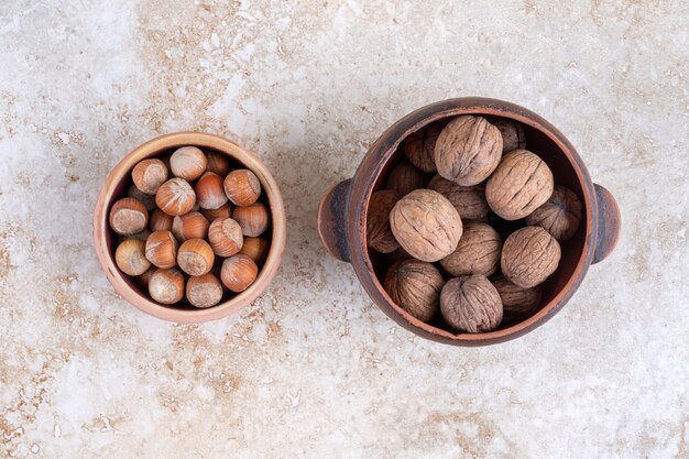 Un cuenco de avellanas y nueces en un cuenco, sobre la mesa de mármol