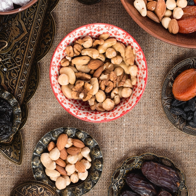 Cuenco de cerámica y metalizado con nueces orgánicas sobre mantel.