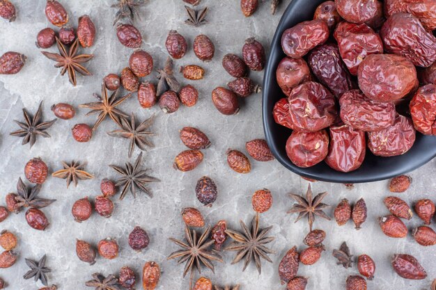 Cuenco de escaramujos secos sobre mesa de piedra.