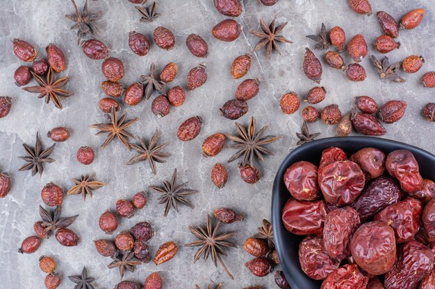 Cuenco de escaramujos secos sobre mesa de piedra.