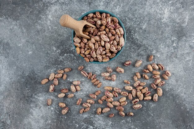 Cuenco de frijoles secos sobre mármol.