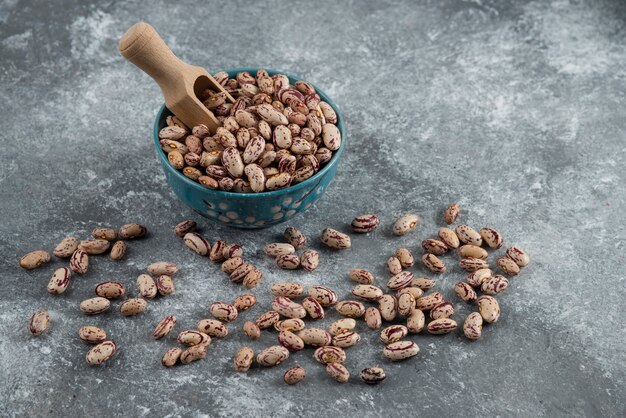 Cuenco de frijoles secos sobre mármol.