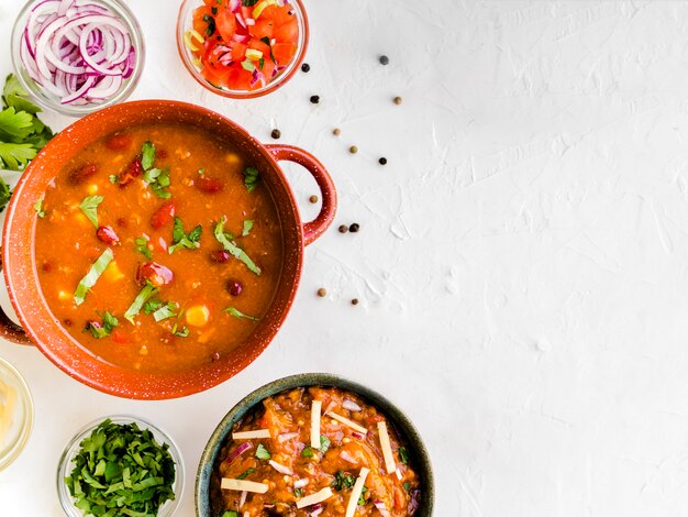 Cuenco con guarnición junto a tazas de verduras.