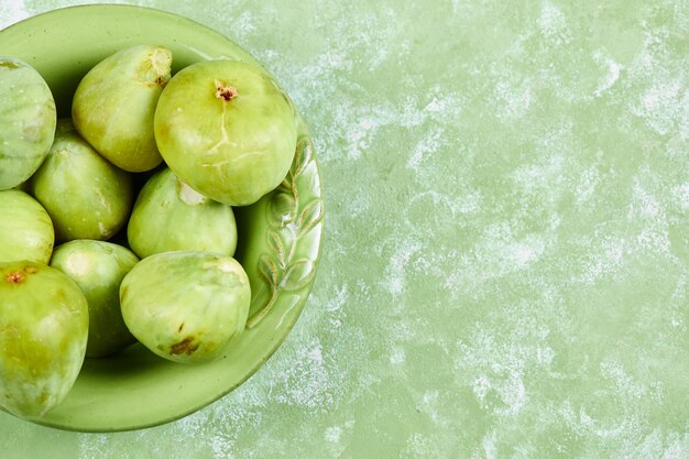 Un cuenco de jugosos higos verdes en verde.