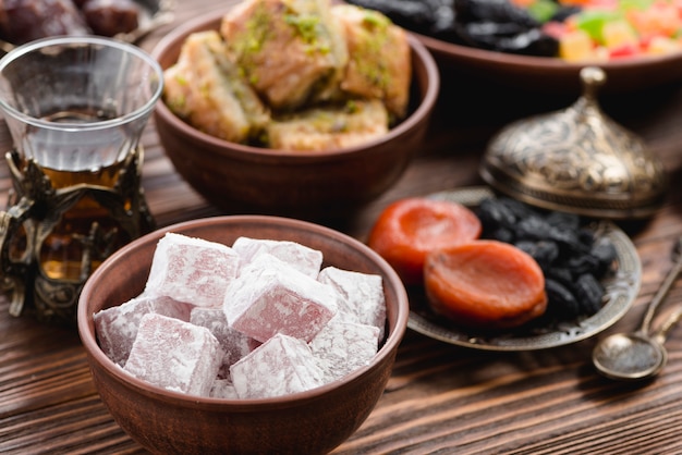 Foto gratuita cuenco de lukum; té y frutos secos en mesa