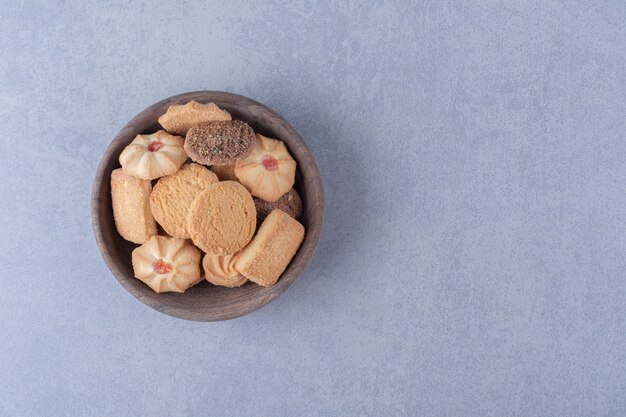 Foto gratuita un cuenco de madera de deliciosas galletas dulces.