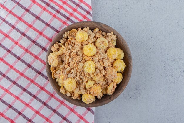 Un cuenco de madera de deliciosos cereales saludables sobre un mantel. Foto de alta calidad