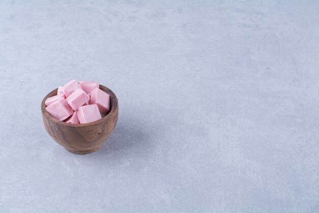 Un cuenco de madera lleno de pastelería dulce rosa Pastila