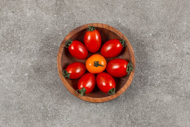 Cuenco de madera lleno de tomates cherry.