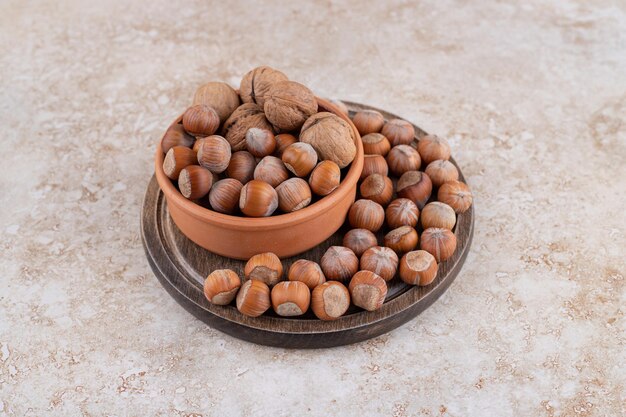 Foto gratuita un cuenco de madera de nueces de macadamia y nueces