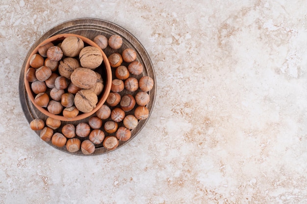 Foto gratuita un cuenco de madera de nueces de macadamia y nueces.