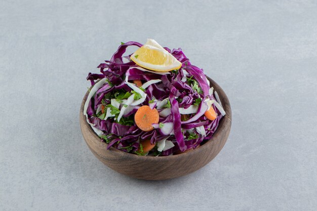 Un cuenco marrón de verduras mixtas, sobre el mármol.