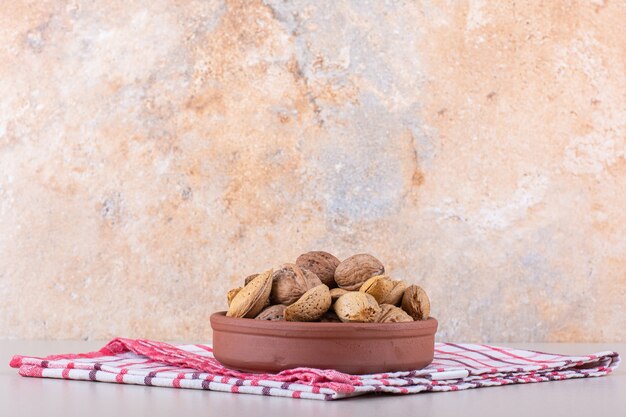 Cuenco de nueces y almendras orgánicas sin cáscara sobre fondo blanco. Foto de alta calidad