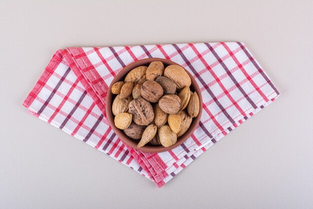 Cuenco de nueces y almendras orgánicas sin cáscara sobre fondo blanco. Foto de alta calidad