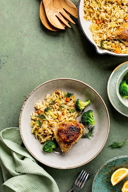 Foto gratuita cuenco con pasta de pollo orzo con verduras al estilo mediterráneo sobre un fondo verde