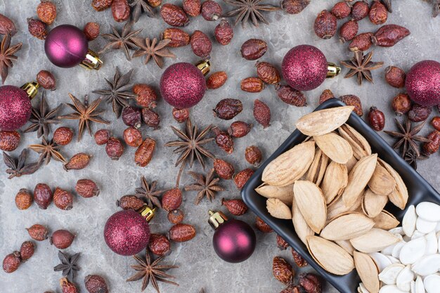 Cuenco de pistacho y semillas de calabaza con rosa mosqueta y bolas de Navidad.