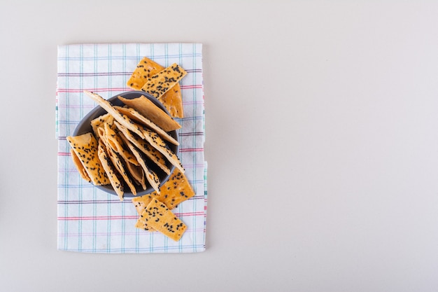 Cuenco profundo de galletas con semillas negras sobre fondo blanco. Foto de alta calidad