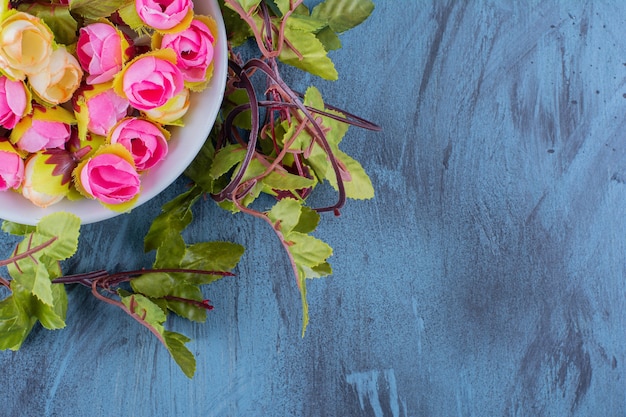 Un cuenco con rosas de colores artificiales en azul.