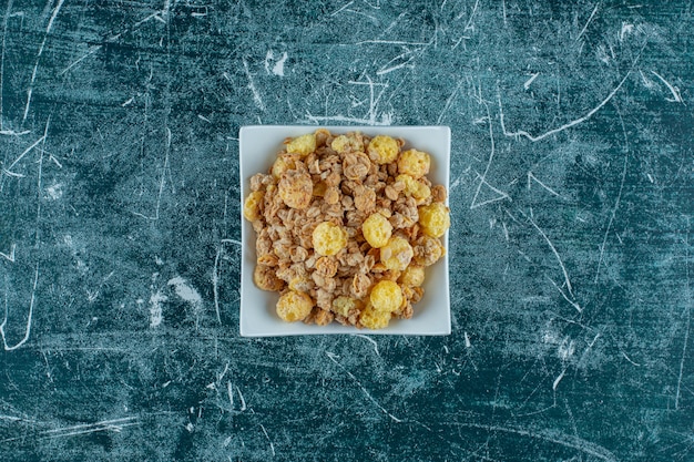 Un cuenco de sabroso muesli, sobre fondo azul. Foto de alta calidad