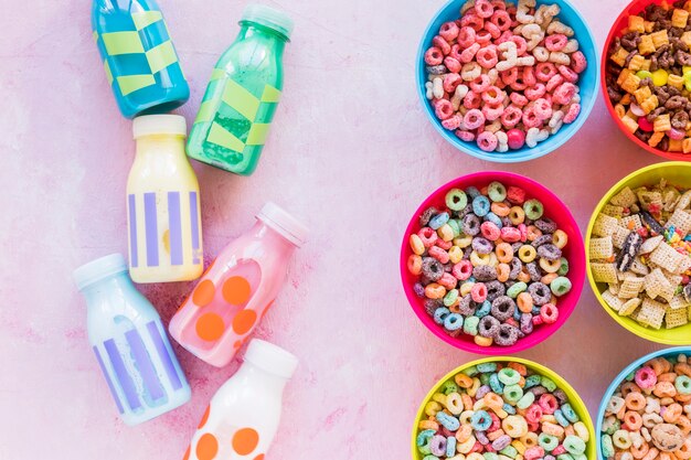 Cuencos brillantes de cereales con leche en mesa