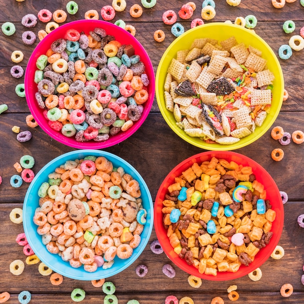 Cuencos brillantes con cereales en mesa de madera