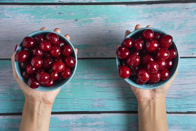 Foto gratuita cuencos de cereza en manos de una persona.