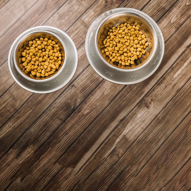 Cuencos con comida para mascotas en el piso