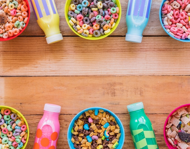 Cuencos con diferentes cereales y botellas de leche.