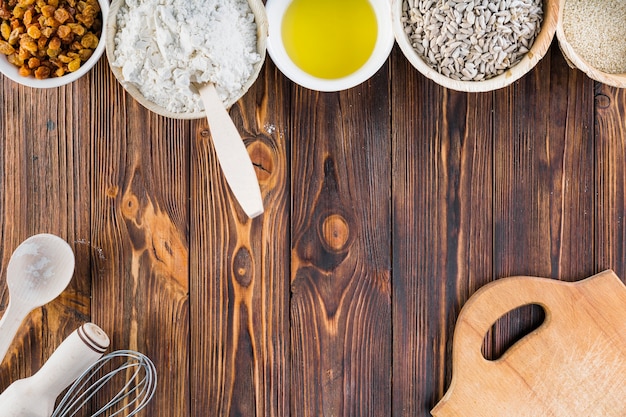 Cuencos de ingredientes para hornear en la mesa de madera oscura