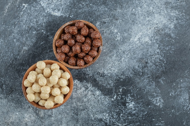 Cuencos de madera con bolas de maíz dulce en gris.