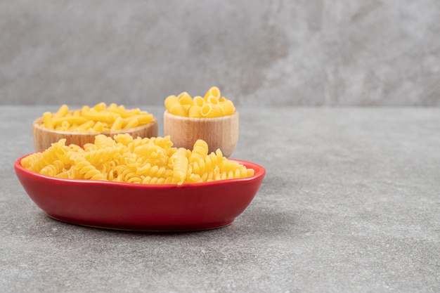 Cuencos de pasta cruda variada sobre superficie de mármol