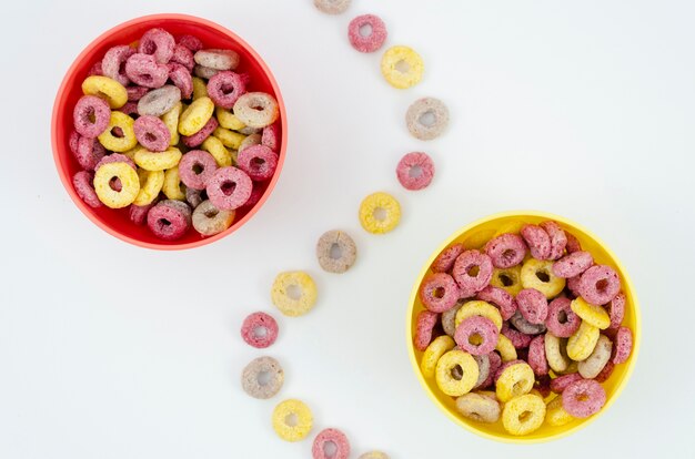 Cuencos rojos y amarillos separados por un rastro de aros de frutas