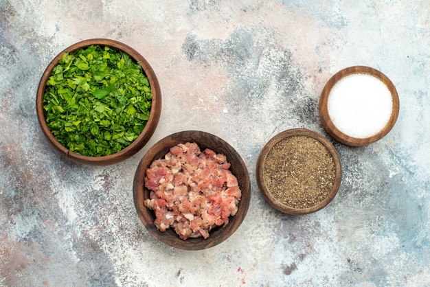 Cuencos de vista superior con diferentes especias verduras carne sobre fondo desnudo espacio libre comida foto