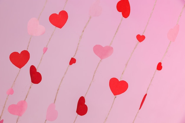 Foto gratuita cuerdas compuestas por corazones en un fondo rosa