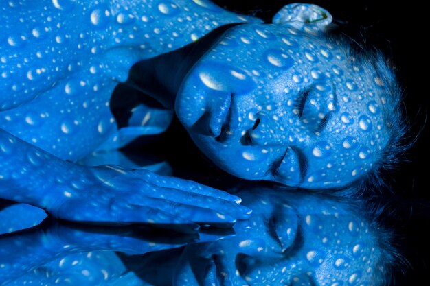 El cuerpo de la mujer con estampado azul y su reflejo.