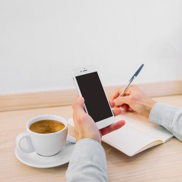 Cultivar las manos masculinas escribiendo desde el teléfono inteligente