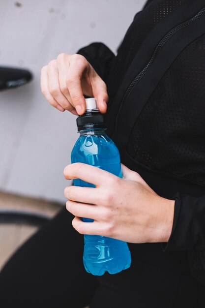 Cultive deportista abriendo la botella de agua