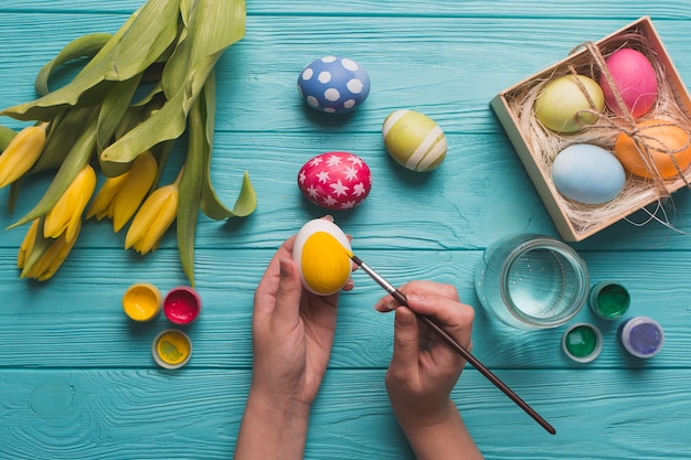 Foto gratuita cultive las manos para colorear los huevos