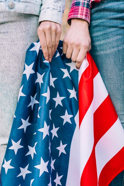 Cultive las manos femeninas con la bandera colorida de los EEUU