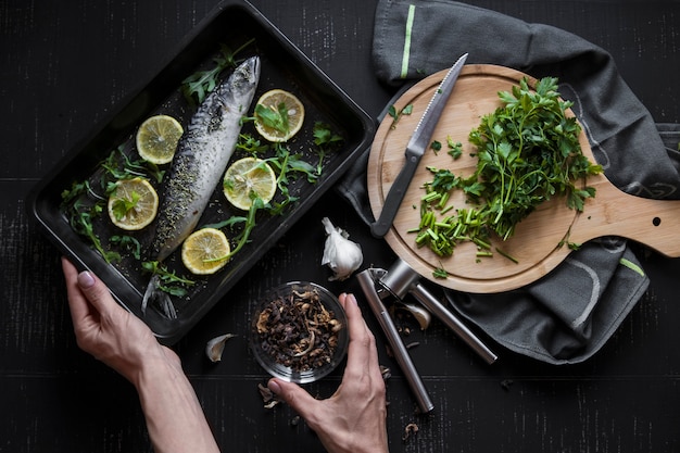 Cultive las manos sosteniendo especias y pescado