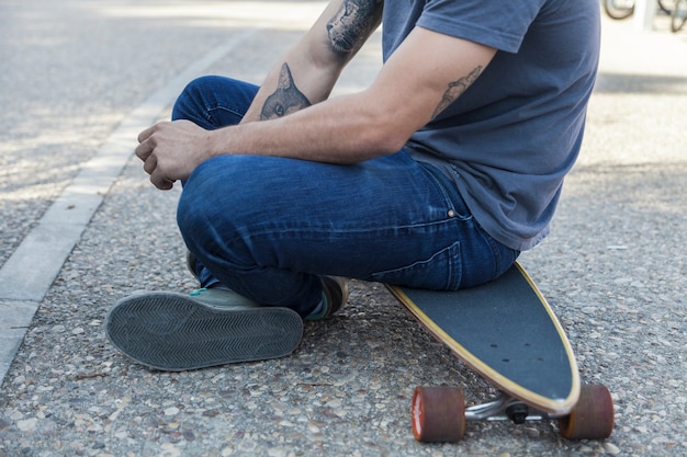 Cultivo hombre descansando en longboard