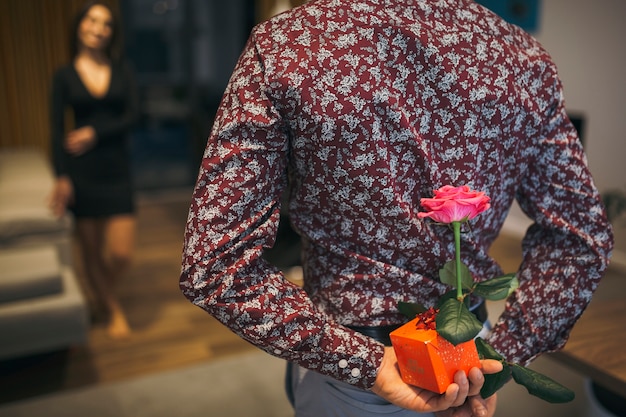 Cultivo hombre escondiendo regalos para mujer