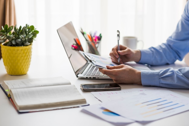 Cultivo hombre escribiendo en documentos en la oficina