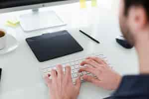 Foto gratuita cultivo hombre escribiendo en el teclado de la computadora